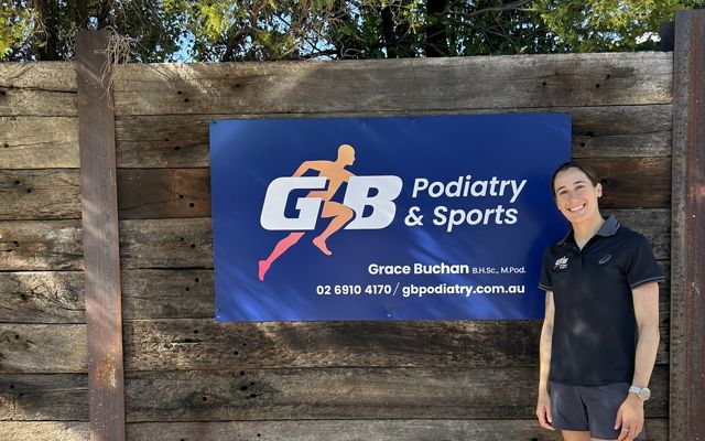 Grace Buchan at the GB Podiatry and Sports clinic sign